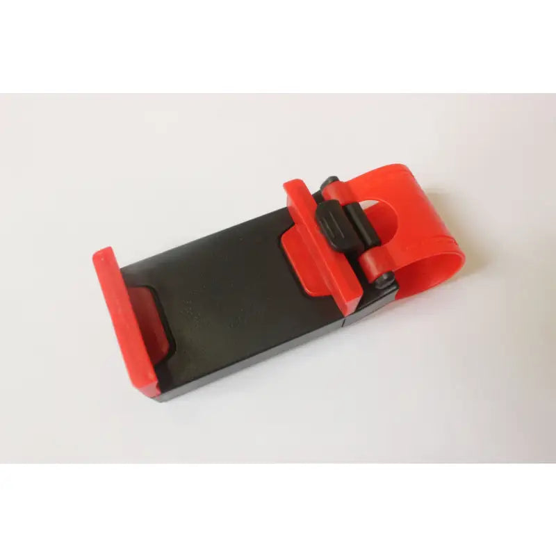 there is a cell phone holder with a red handle on a white surface