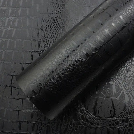a close up of a black leather roll on a black surface
