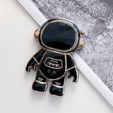 a black and gold astronaut charm with a white background