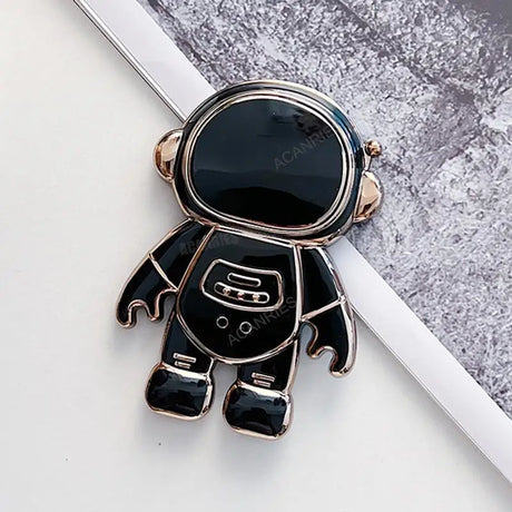 a black and gold astronaut charm with a white background