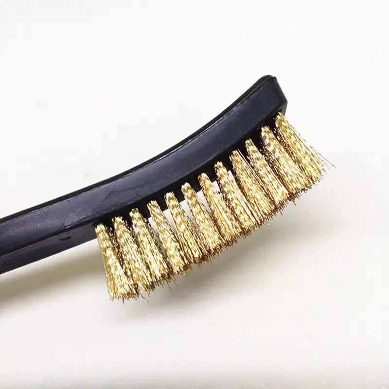 a black and gold hair brush with gold spikes