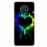 a black heart painted on a black background with colorful splats