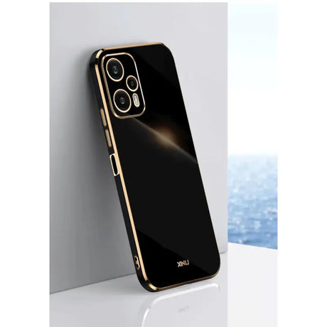 the back of a black iphone case with gold trim