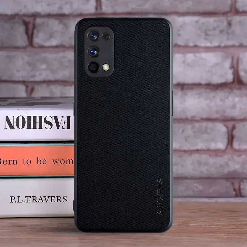 the back of a black iphone case sitting on top of a stack of books