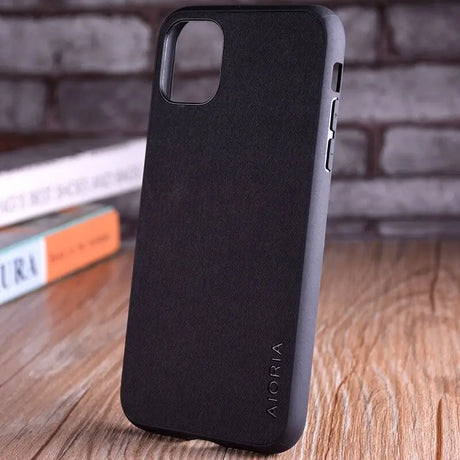 the back of a black iphone case on a wooden table