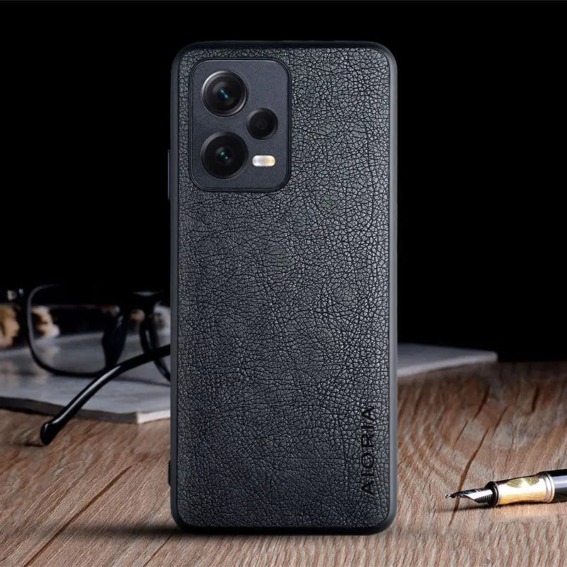 the back of a black leather case with a pen and glasses on it