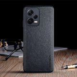 the back of a black leather case with a pen and glasses on it