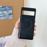 Black leather phone case with a circular embossed design held in a hand.