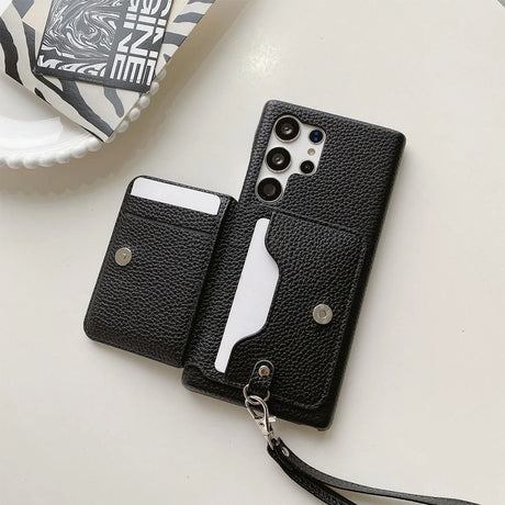 Black leather phone case with built-in card holder and wrist strap.