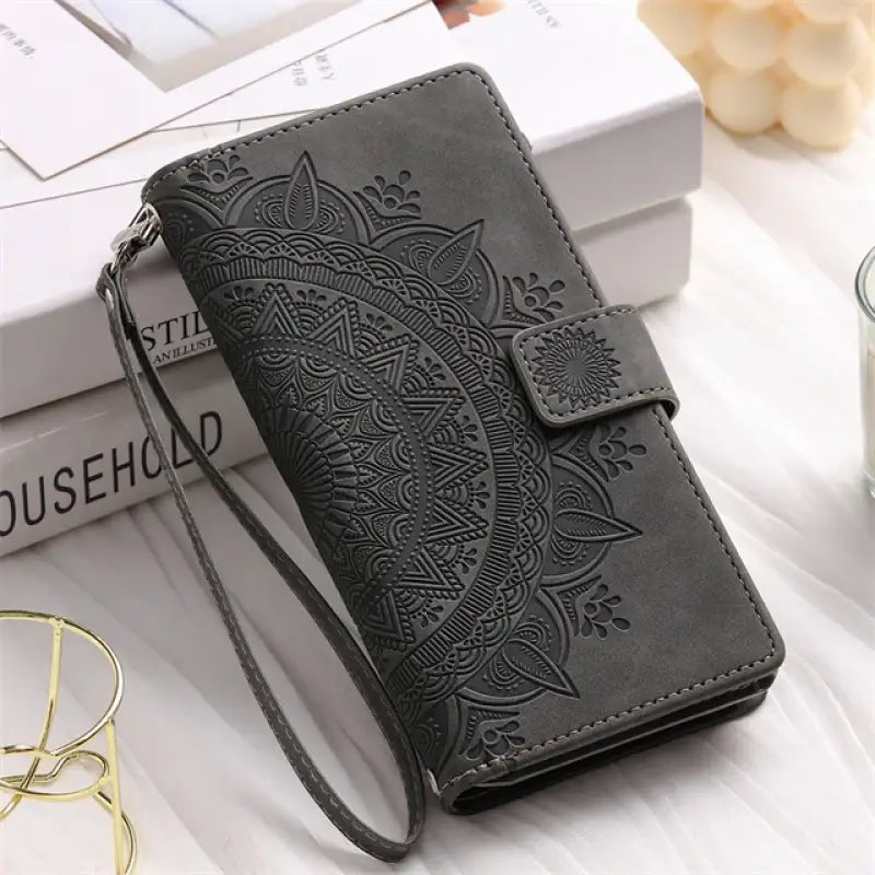 a black leather wallet case with a flower design