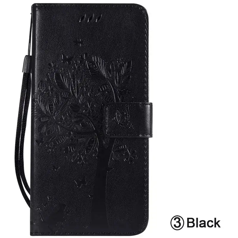 the back of a black leather wallet case with a tree design
