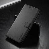Black leather wallet-style phone case with a magnetic clasp.