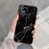 a woman holding a book and a black marble phone case