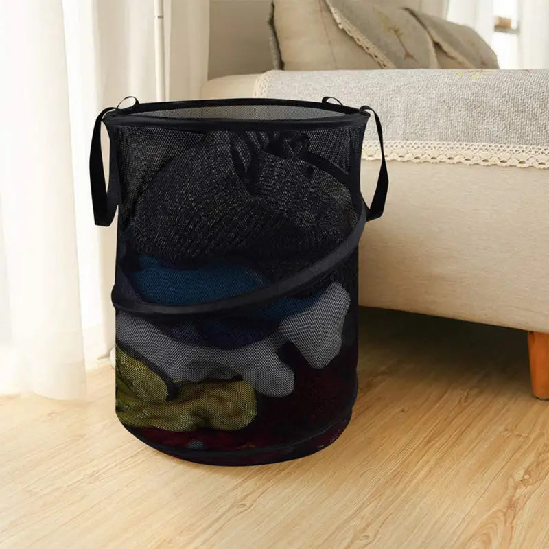 a black mesh laundry bag with three different colored clothes