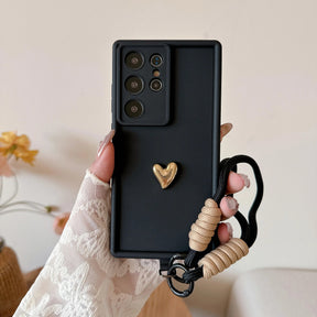 Black phone case with gold heart and lanyard.