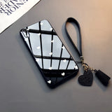 a black phone case with a heart shaped mirror