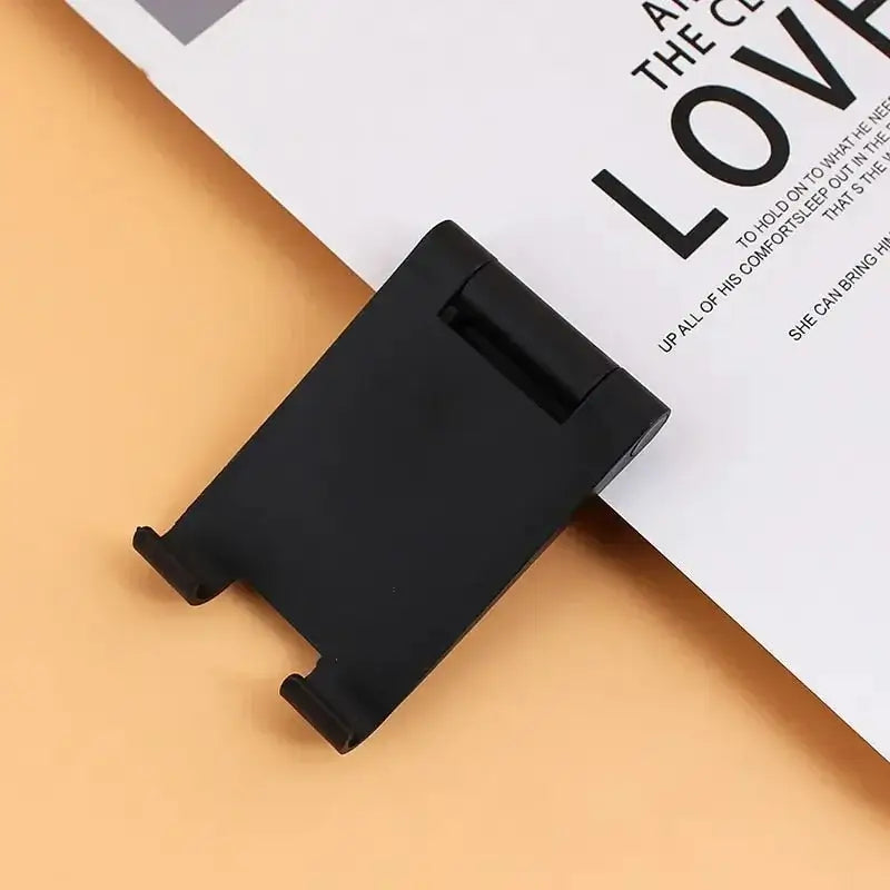 a black phone holder on top of a white paper