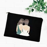 a black pouch bag with a drawing of two women sitting on the back