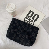 a black purse bag with a white and black flower pattern