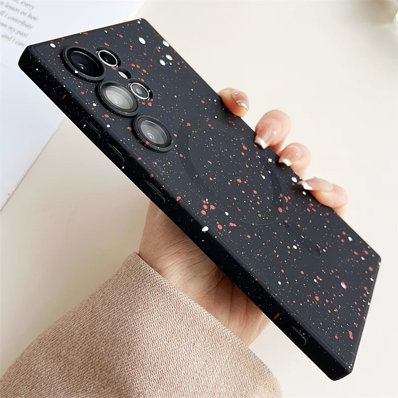 Someone holding a black and red phone case with a speckled design