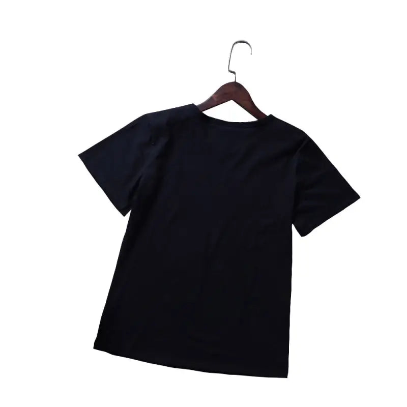 a black t - shirt hanging on a wooden hanger