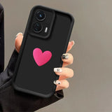 A black smartphone with a pink heart on its case.