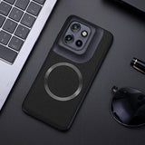 Black smartphone in a textured case with a prominent camera module and a magnetic ring.