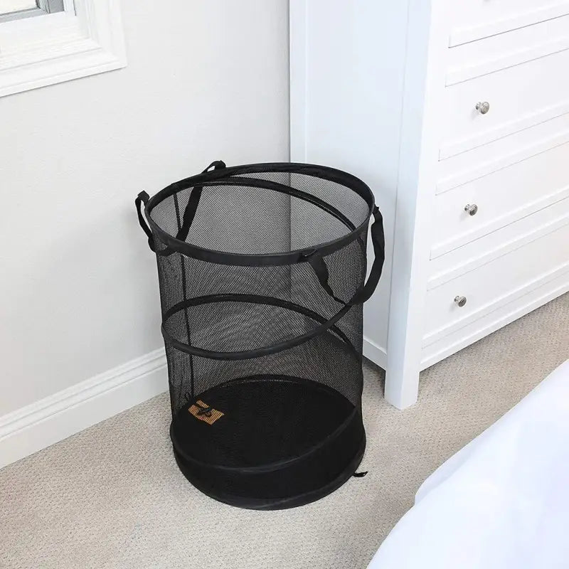 a black trash can be found in the corner of the bedroom