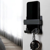 a black phone holder with a key hanging on it