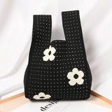 a black and white bag with a flower on it