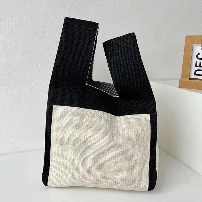 a black and white bag sitting on top of a white shelf