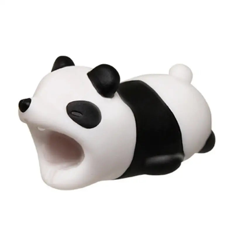 a small toy panda bear laying down on the ground