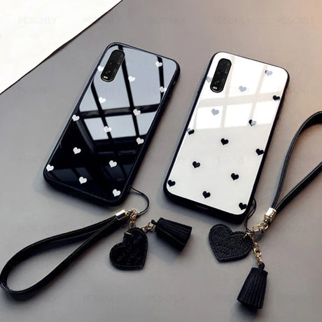 a black and white phone case with a heart charm