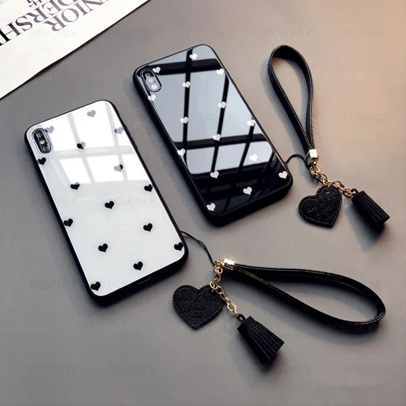 a black and white phone case with a heart charm