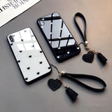 a black and white phone case with a heart charm