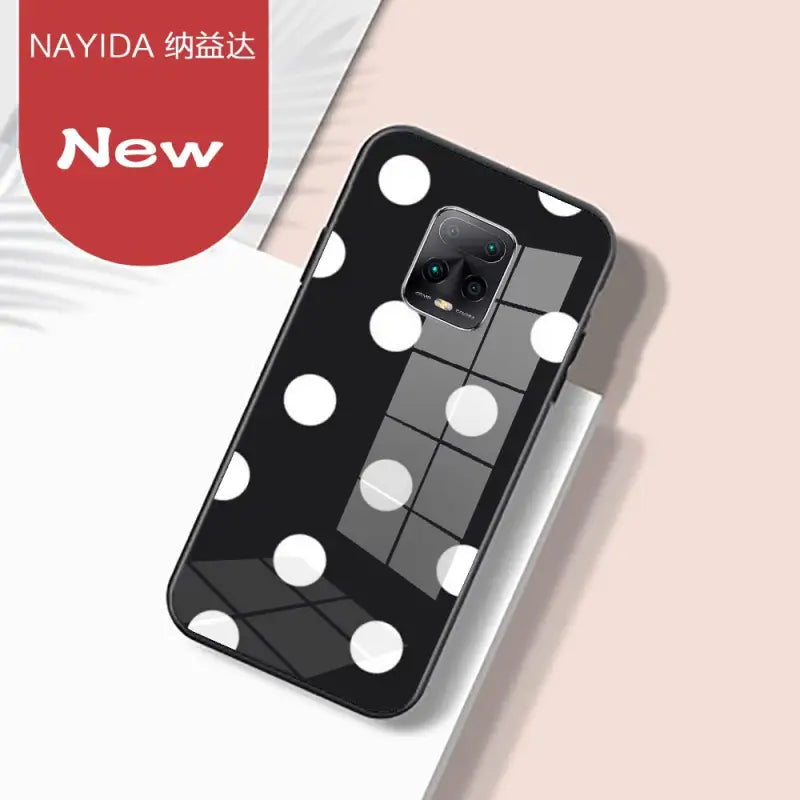 a close up of a cell phone with a black and white polka dot design