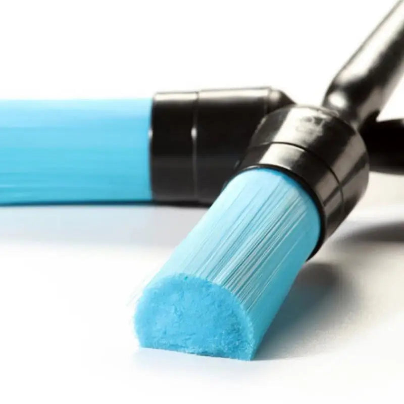 a blue paint brush with a black handle