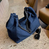 a blue denim bag with a chain on the handle