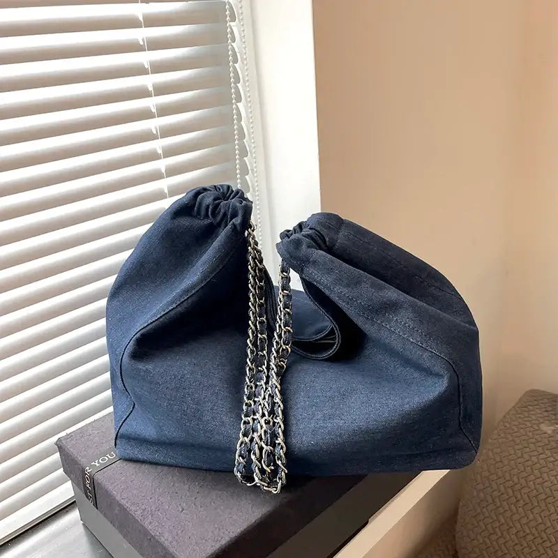 a blue denim bag with a chain strap