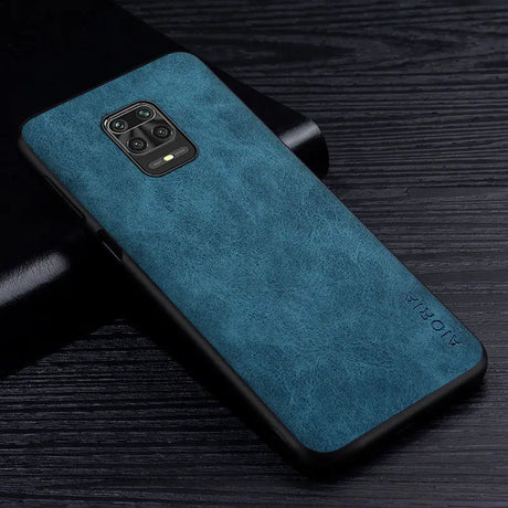 the back of a blue leather case on a black table