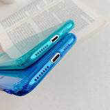 a blue phone case sitting on top of a book