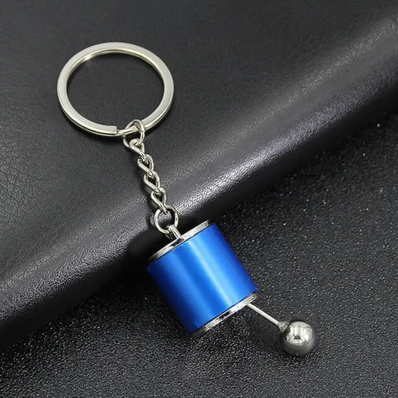 a blue pipe keychai with a metal ball on it