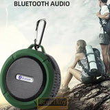 a green portable speaker with a man standing on top of it