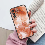 someone holding a book and a phone case with a marble design