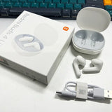 There is a box with earphones and a charger on a desk