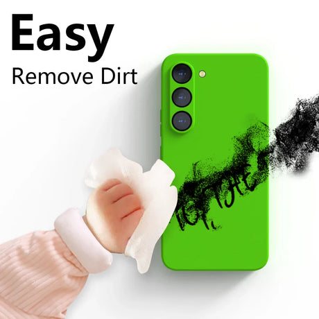 Bright green smartphone with three camera lenses and black smudges being wiped off by a hand with a cloth.