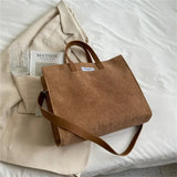 a brown bag sitting on top of a bed