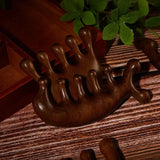 a wooden table with a small plant and two small wooden frogs