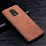 the back of a brown leather case on a black table