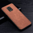 the back of a brown leather case on a black table